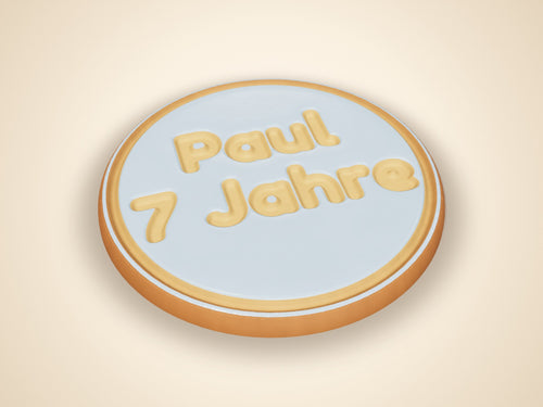 Gebackener Keks in runder Form mit geprägtem Text „Paul 7 Jahre“, mit hellblauem Zuckerguss