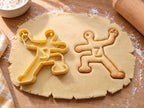 Butter-gelber Handballspieler-Ausstecher mit Prägung neben gebackenem Keks mit Wurfarm, Ball und Nummer 7 auf hellem Holz