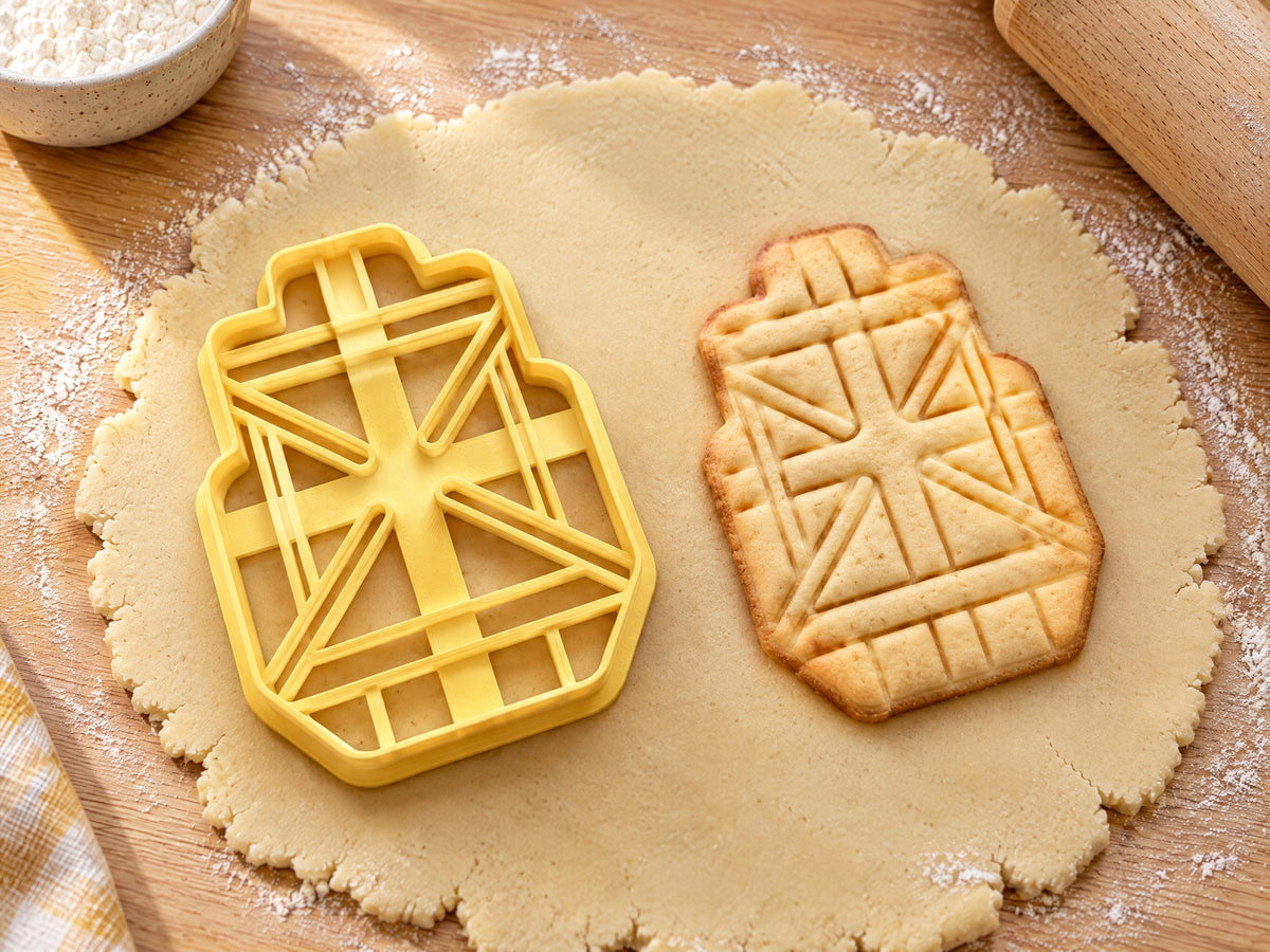 Butter-gelber Klebeband-Ausstecher mit Prägung neben gebackenem Keks mit kreuz und quer geprägten Streifen auf hellem Holz