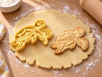 Butter-gelber Meeresschildkröten-Ausstecher mit Prägung neben gebackenem Keks mit Panzerplatten und Flossen auf hellem Holz