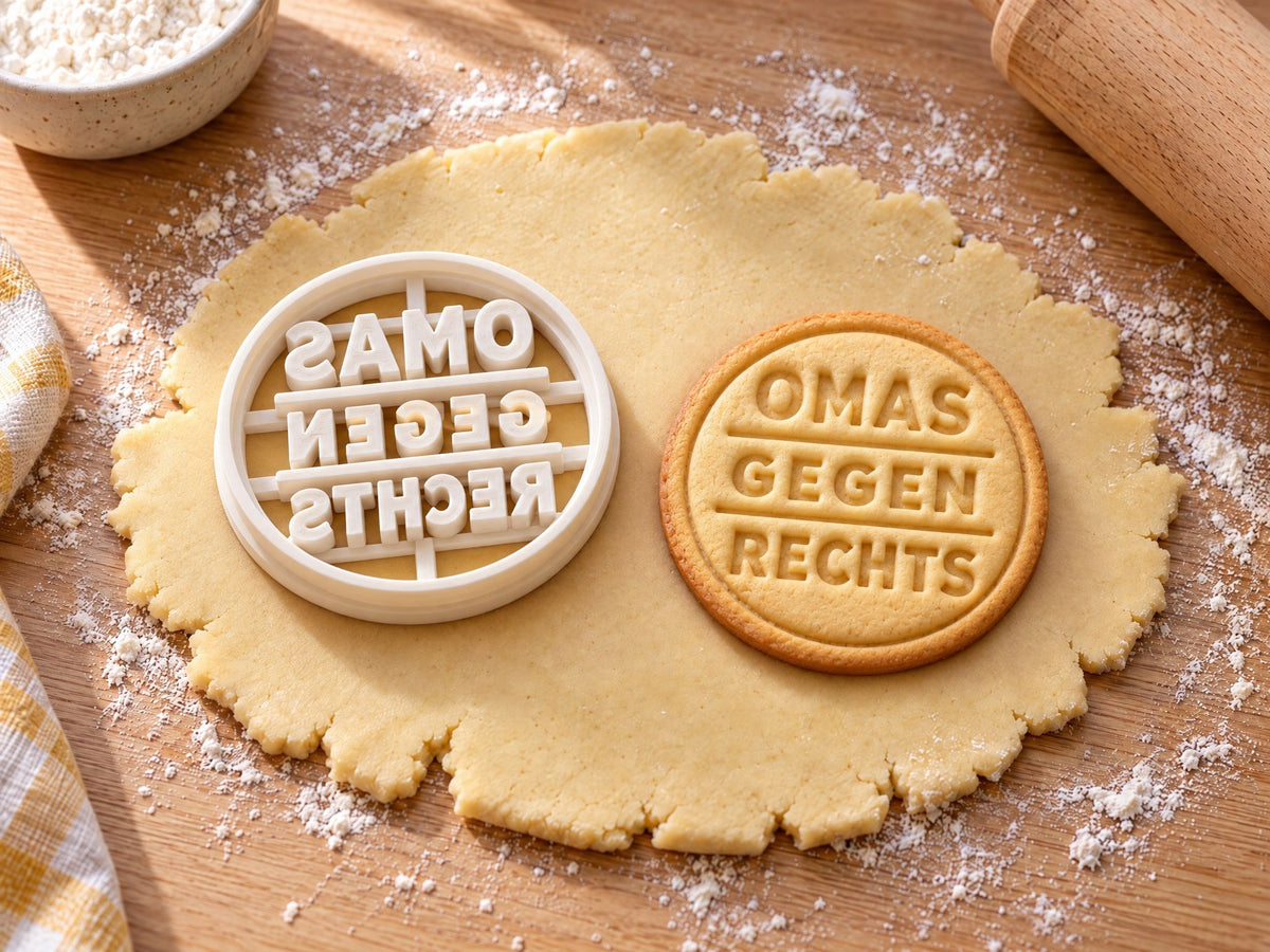 Omas gegen Rechts-Ausstecher mit Prägung neben gebackenem Keks auf hellem Holz