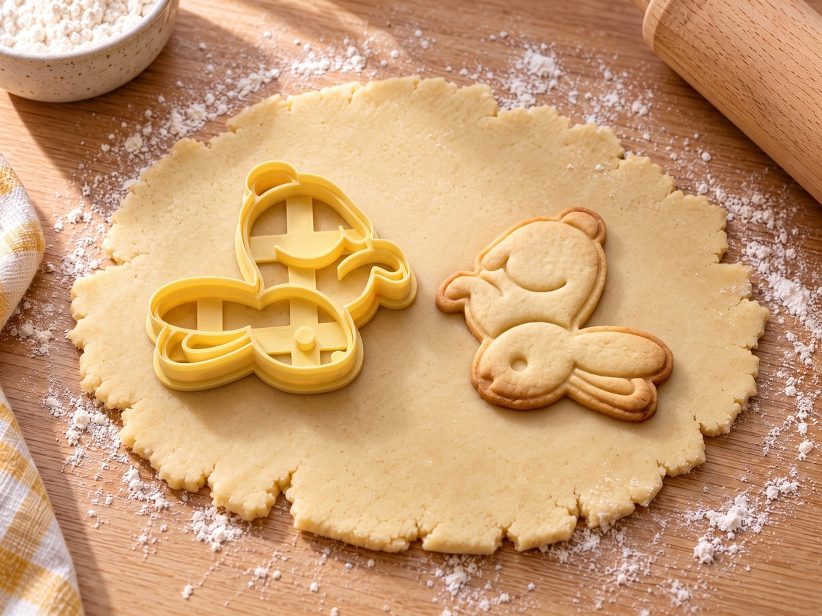 Butter-gelber Osterhasen-Ausstecher mit Prägung neben Keks mit springendem Hasen, Puschelschwanz und langen Ohren auf hellem Holz