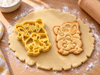 Butter-gelber Osterwichtel-Ausstecher mit Prägung neben Keks mit Hasenohren, Gänseblümchen an der Mütze und Bart auf hellem Holz