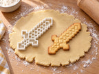 Pixel-Schwert-Ausstecher mit Prägung neben gebackenem Keks auf hellem Holz