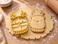 Butter-gelber Rentier-Ausstecher mit Prägung neben gebackenem Keks mit Geweih, Lachaugen und Rippenschal auf hellem Holz