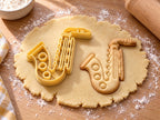 Butter-gelber Saxophon-Ausstecher mit Prägung neben gebackenem Keks mit Klappen, Tonlöchern und Mundstück auf hellem Holz