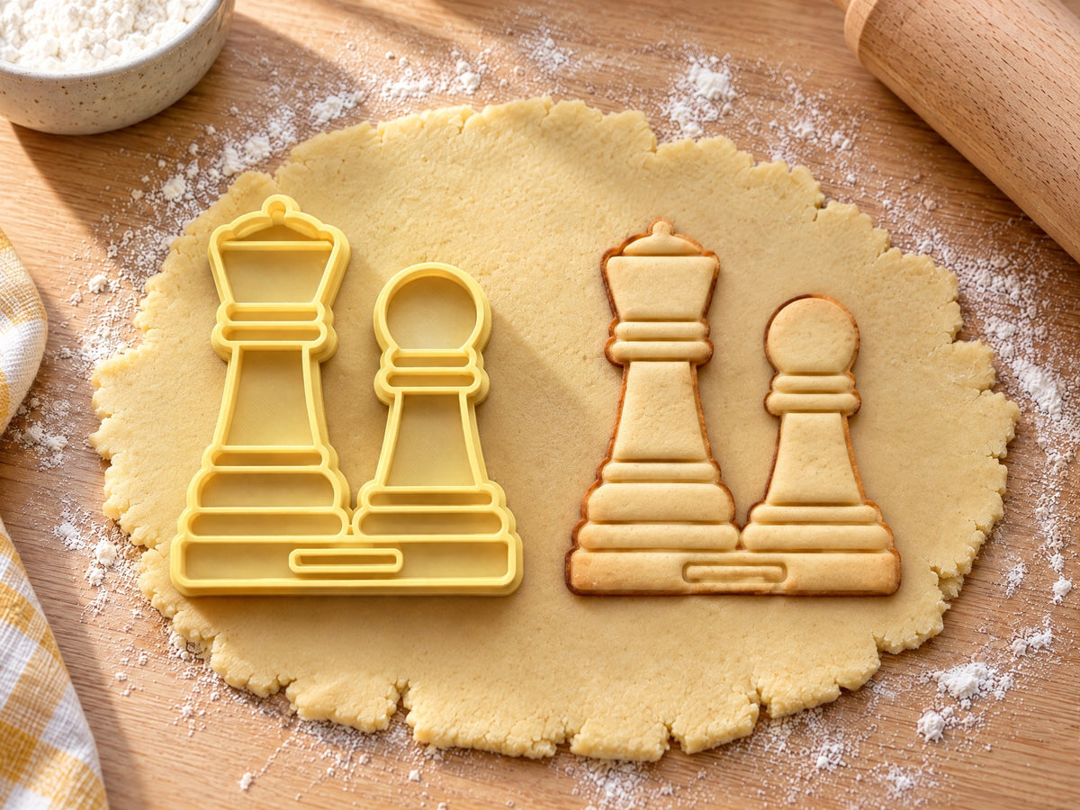 Butter-gelber Ausstecher mit Prägung als Dame und Bauer neben gebackenem Keks mit geprägten Kronen und Sockelstufen auf hellem Holz