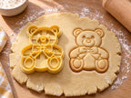 Butter-gelber Teddybär-Ausstecher mit Prägung neben Keks mit Schleife, Schnauze und runden Fußsohlen auf hellem Holz